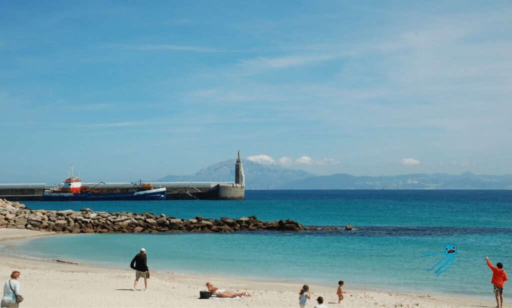 People enjoying the panaromic view of the beach in Spain with toddlers.