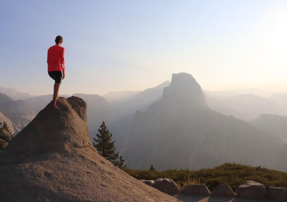 Emilie at the top of a rock looking at the sunrise at Glacier Point in Yosemite National Park