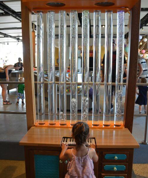 A girl playing with a unique piano at TELUS Spark in Calgary