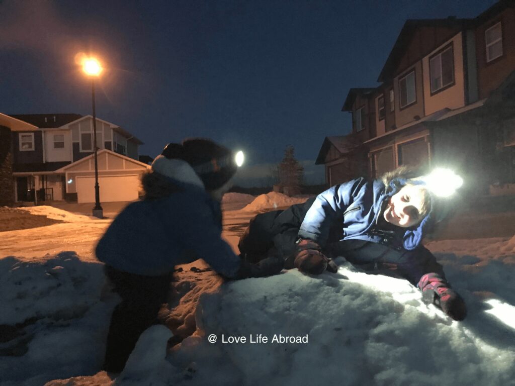 Kids are having fun at night in the winter with their headlamps